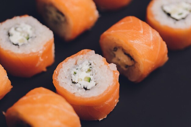 Sushi japonais frais traditionnel roule sur un fond noir