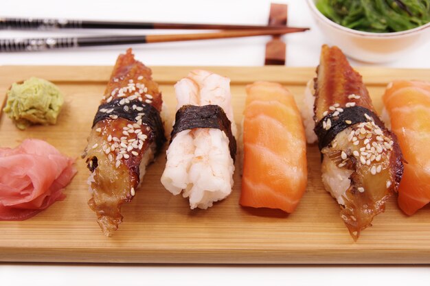 Sushi japonais Sushi set sur plateau en bois servi avec sauce soja au gingembre et salade d'algues Sushi rolls saumon nigiri crevettes nigiri unagi nigiri