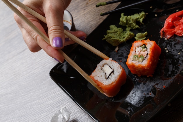 Sushi. Main avec des baguettes