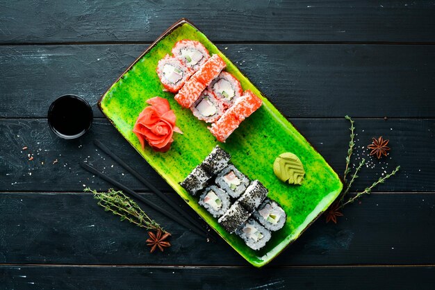 Sushi et petits pains sur l'assiette Vue de dessus Espace libre pour votre texte Sur fond noir