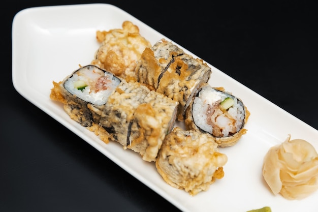 Sushi sur une plaque de pierre avec un fond noir