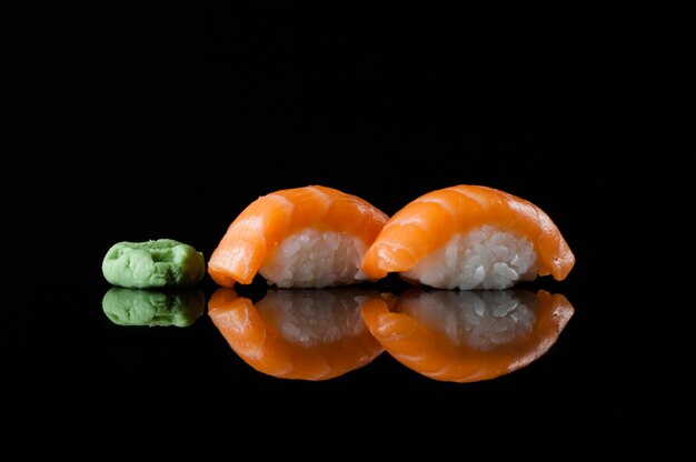 Sushi avec riz et wasabi sur fond sombre avec reflet