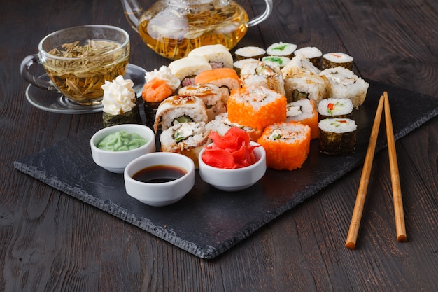 Sushi Roll au saumon, anguille, thon, avocat, fromage à la crème Philadelphia, caviar tobica, chuka. Menu de sushi. Cuisine japonaise sur table