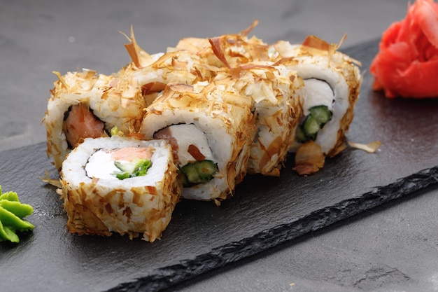 Sushi roll avec des copeaux de thon sur assiette