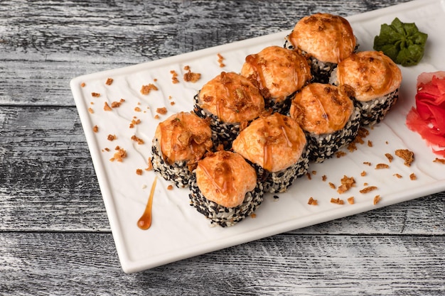 Sushi roule des sushis avec du poisson sur un fond en bois blanc