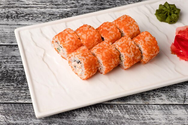 Sushi roule des sushis avec du poisson sur un fond en bois blanc