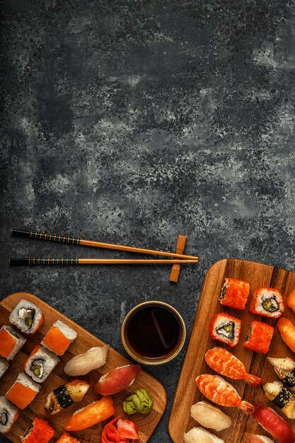 Sushi et rouleaux de sushi sur plaque en bois, vue du dessus