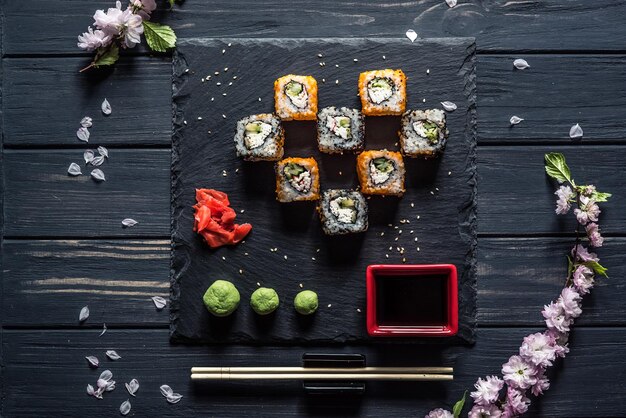 Sushi sakura branche sauce soja sur un tableau noir