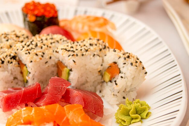 Photo sushi sashimi de thon rouge et saumon norvégien fumé au wasabi et riz japonais au vinaigre et graines de sésame et de pavot