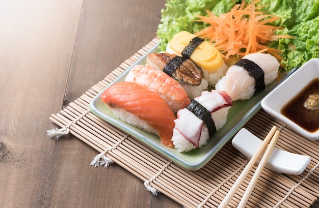 sushi avec sauce et wasabi sur plaque de bois