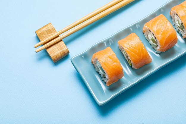 Photo sushi avec saumon sur une assiette rectangulaire bleue