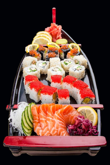 Sushi situé dans un bateau en bois sur fond noir