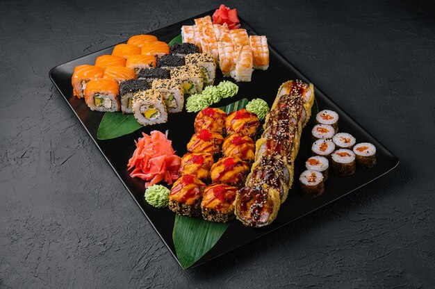 Sushis japonais assortis sur une plaque en pierre noire