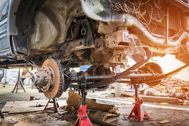 Suspension de voiture ancienne et rouillée, qui enlève les roues pour la réparation.