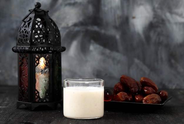 Susu Kurma ou smoothie aux fruits de dattes à base de lait et de fruits de palmier dattes sur fond de bois avec lanterne Concept Ramadan