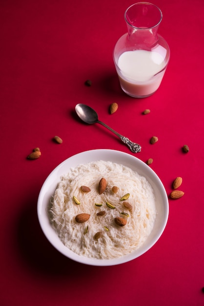 Sutarfeni sucré indien ou sutar feni ou firni ou seviyan ou laccha, râpé, farine de riz feuilleté rôti au ghee, mélangé avec du sucre fondu pour former une barbe à papa, garni de pistache et d'amandes