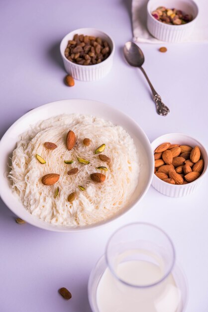 Sutarfeni sucré indien ou sutar feni ou firni ou seviyan ou laccha, râpé, farine de riz feuilleté rôti au ghee, mélangé avec du sucre fondu pour former une barbe à papa, garni de pistache et d'amandes