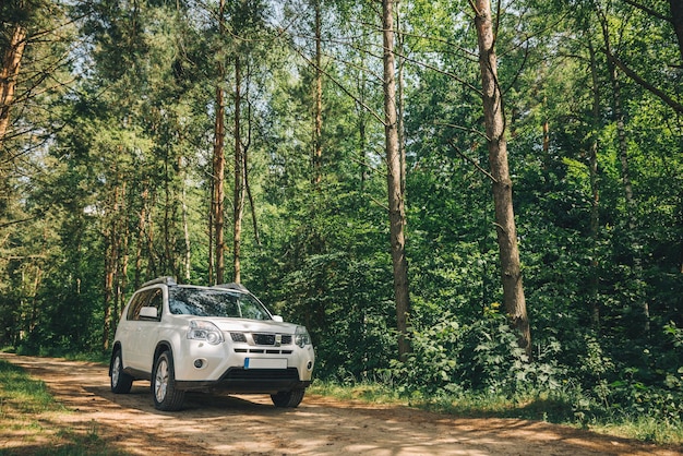 SUV blanc dans le style de vie du concept de voyage en voiture forestière