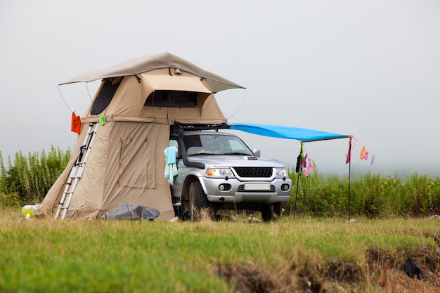 SUV avec tente sur le toit sur la côte de la mer