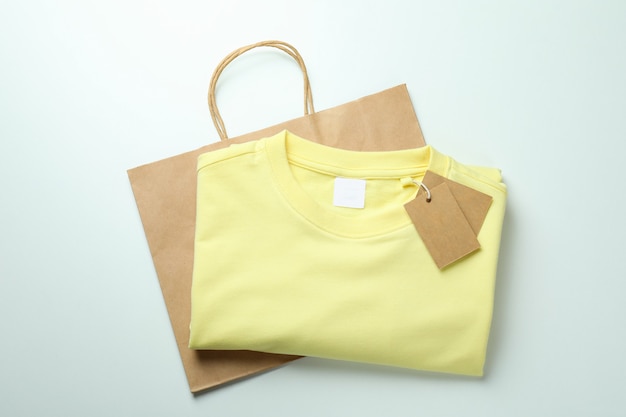 Sweat avec étiquettes et sac sur surface blanche