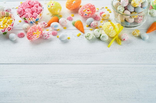 Sweet Easter concept Sweet Easter kids vacances assortiment guimauves lapin chocolats oeufs de Pâques bonbons lapin collations sur fond en bois blanc plat poser idée de décoration de Pâques maquette