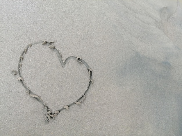 Symbole d'amour sur le sable avec espace de copie