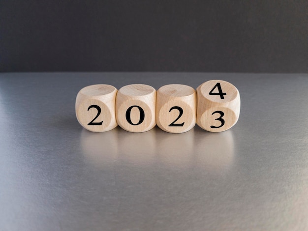Photo symbole de bonne année 2024 les cubes en bois symbolisent le passage de 2023 à la nouvelle année 2024