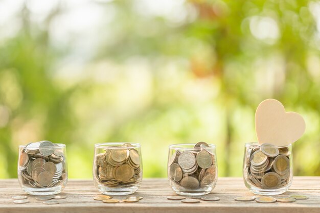 Photo symbole de coeur en bois et pièce en pot clair sur table en bois. économies d'argent pour le concept de l'amour ou de la santé