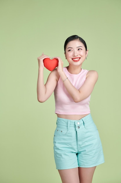 Symbole de coeur rouge de Saint Valentin femme souriante tenir