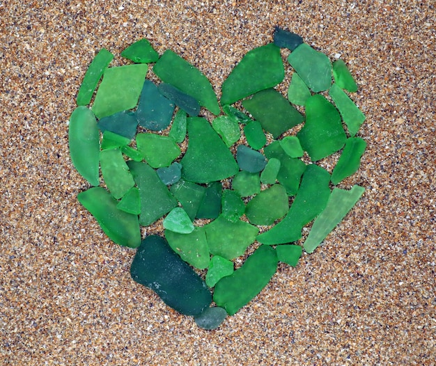 Symbole de coeur de verre de mer vert sur le sable. Plage mer méditerranée. Vacances. Mer du Sud. Vacance