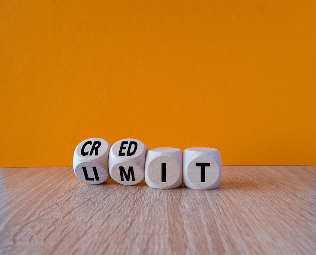 Symbole de crédit et de limite Cubes en bois tournés avec des mots de crédit et de limite Beau fond orange