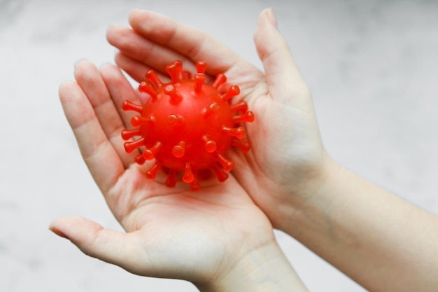 Photo symbole du coronavirus dans les mains femme tenant le virus dans les mains covid19