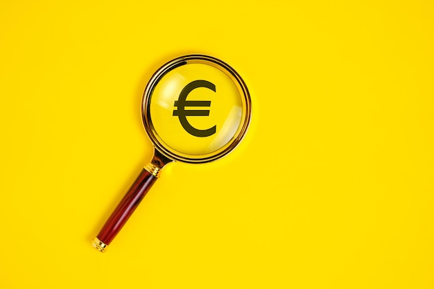 Symbole de l'euro sous la loupe sur fond jaune