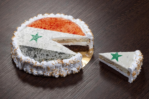 Le symbole de la guerre et du séparatisme un gâteau avec une photo du drapeau de la Syrie est brisé en morceaux