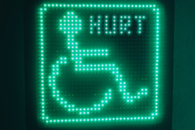 Symbole Lumineux Vert Des Handicapés Accroché Au Mur