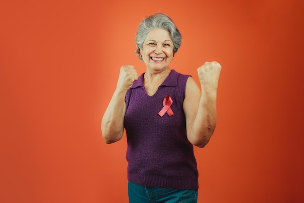 Symbole de protection contre le cancer du sein Femme mature avec ruban rose et t-shirt violet isolé pour la campagne contre le cancer du sein