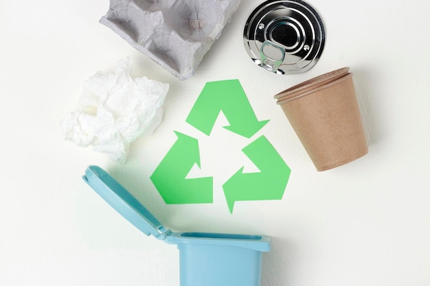Un symbole de recyclage vert des déchets et des déchets de fer en plastique sur la vue de dessus de fond blanc