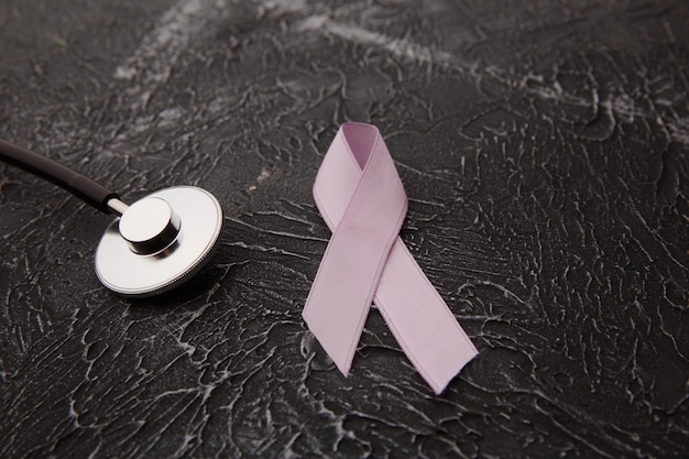 Symbole de la santé des femmes en rose sur gris.