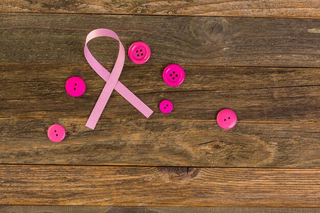 Photo symbole de santé des femmes en ruban rose sur planche de bois.