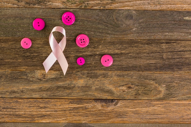 Symbole de santé des femmes en ruban rose sur planche de bois.