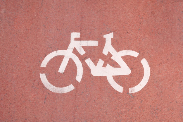 Symbole d'un vélo sur l'asphalte rouge peint en blanc Ligne de cyclisme