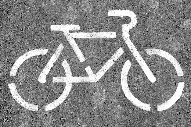Symbole de vélo noir et blanc sur fond d'asphalte texturé