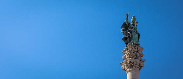 Le symbole de la ville de Lecce (Italie) : Saint Oronzo (Sant'Oronzo) posé sur la colonne au centre de la place principale de la ville. Fond bleu avec espace de copie.