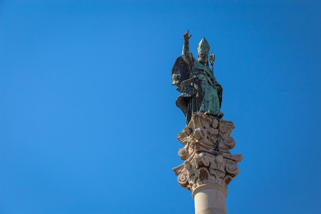 Le symbole de la ville de Lecce (Italie) : Saint Oronzo (Sant'Oronzo) posé sur la colonne au centre de la place principale de la ville. Fond bleu avec espace de copie.