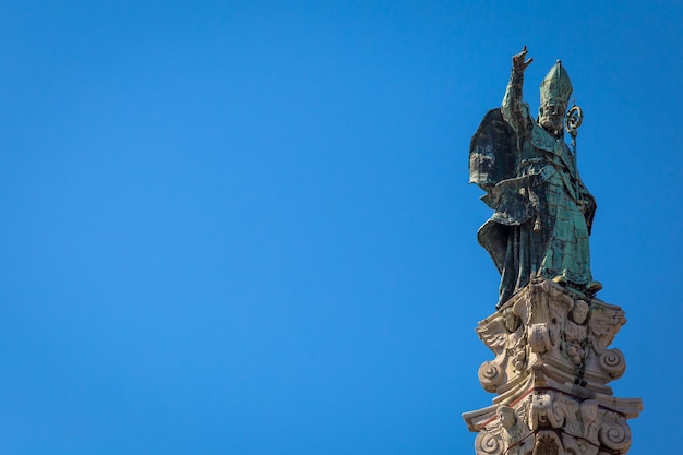 Le symbole de la ville de Lecce (Italie) : Saint Oronzo (Sant'Oronzo) posé sur la colonne au centre de la place principale de la ville. Fond bleu avec espace de copie.