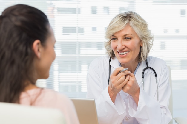 Sympathique femme médecin en conversation avec un patient