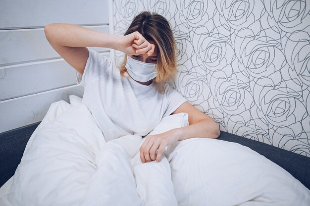 Les Symptômes De La Maladie à Coronavirus (covid-19) Sont Le Nez Qui Coule, Le Mal De Gorge, La Toux Et La Fièvre. Jeune Femme Malade D'une Infection Virale à Coronavirus Propageant Le Virus Corona. Patient Couché Dans Son Lit à La Quarantaine à Domicile