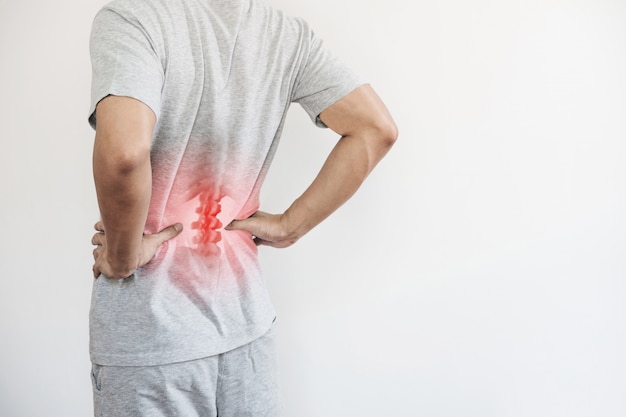 Photo syndrome de bureau, mal de dos et concept de douleur au bas du dos. un homme touchant le bas du dos au point de douleur