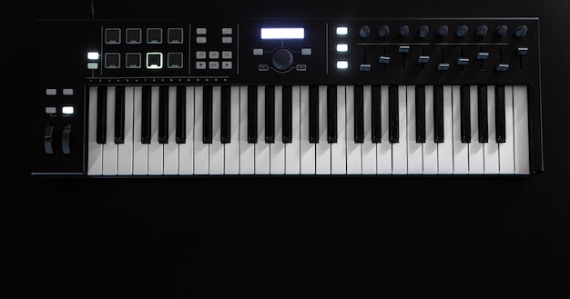 Synthétiseur de touches de piano sur fond noir à plat