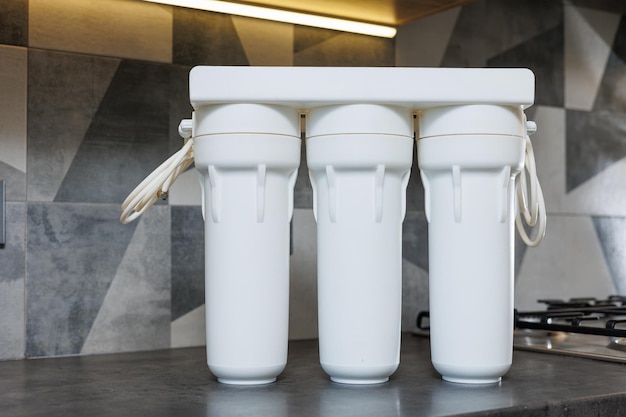 Système de filtration d'eau avec cartouches remplaçables Un système dans un appartement avec trois réservoirs pour nettoyer l'eau sous le robinet